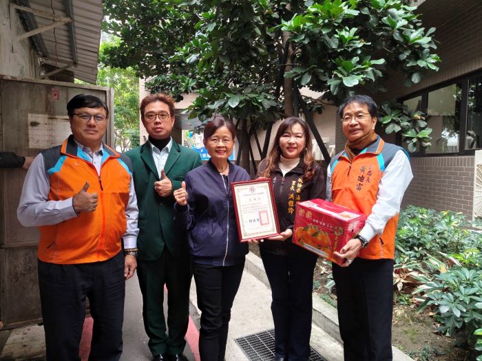 《圖說》湳興里長洪雅鈴感謝郵務同仁以實際行動守護社區弱勢致贈感謝狀，中為板郵局長胡美惠。〈板橋郵局提供〉