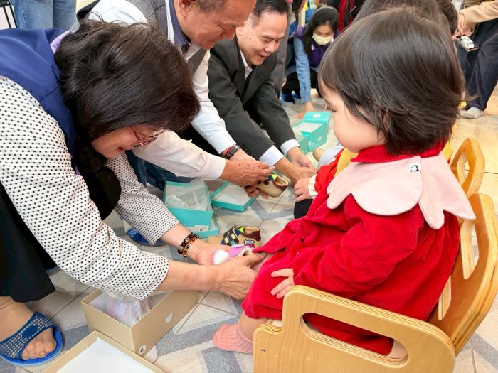 《圖說》李美珍局長等人幫幼兒穿上新鞋。〈社會局提供〉