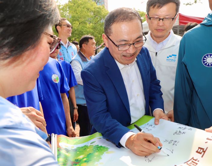 《圖說》侯友宜市長簽名祝福坪頂國小百年校慶圓滿成功,右一教育局長張明文。〈教育局提供〉