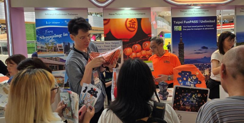 《圖說》菲律賓民眾至新北市政府觀光旅遊局展區民眾熱絡詢問旅遊資訊及集章活動領取贈品。〈觀旅局提供〉